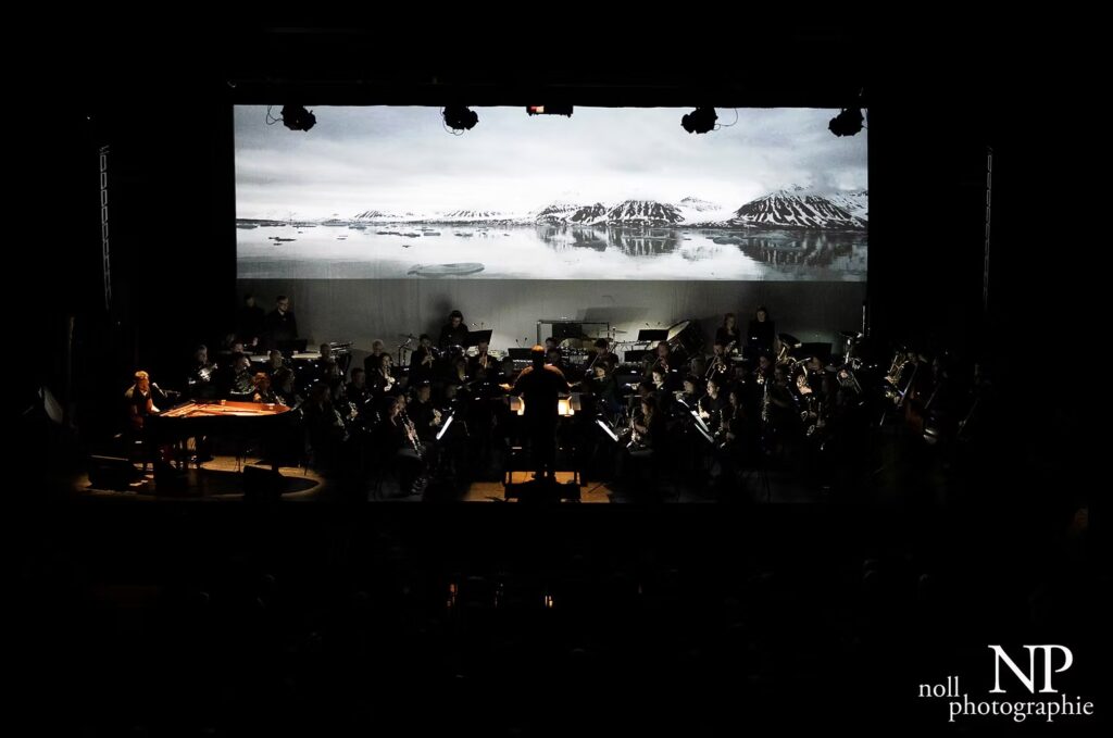 Rougge and the OHV Orchestra performing live, with an Arctic landscape projected on a large screen
